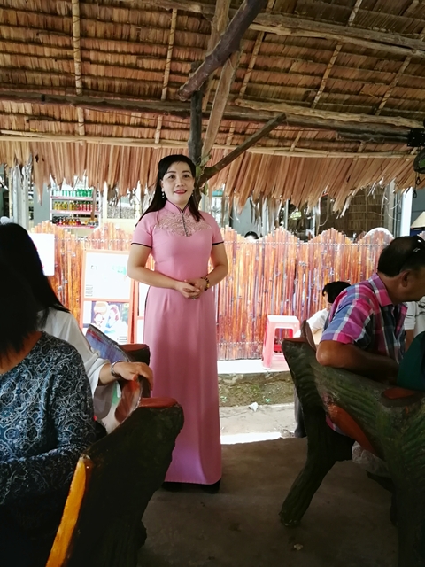 Woman in pink dress standing at a dining area.