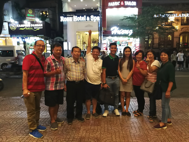 Group of people posing on a city street at night.