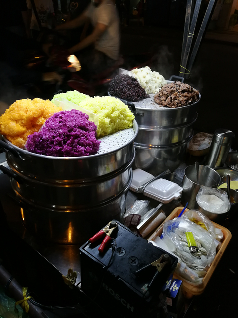 Colorful display of steamed rice in various colors.