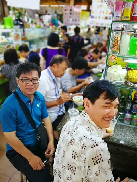 People eating in a busy food stall.