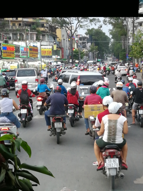 Busy street with motorbikes and cars.