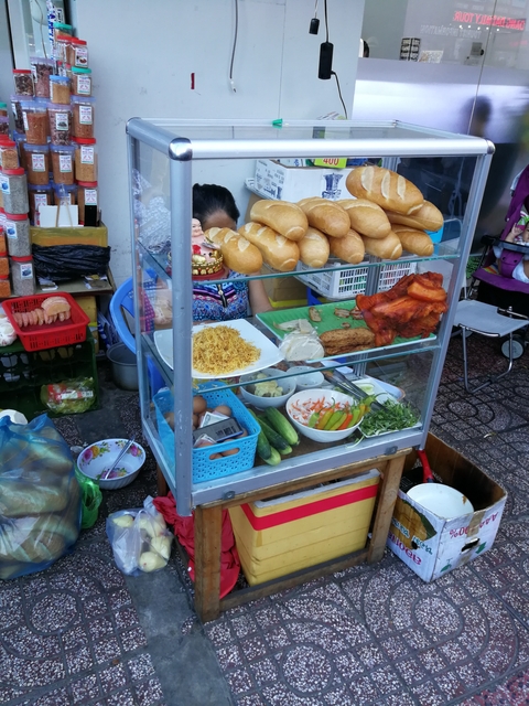 Street food vendor selling sandwiches and ingredients.