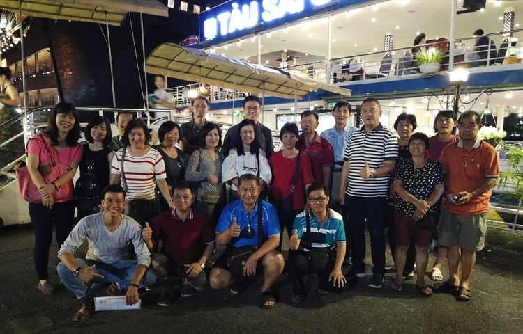 Group of tourists posing together outdoors at night.
