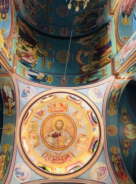 Colorful frescoed dome of a church interior featuring religious figures.