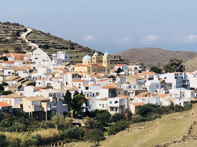 Hillside village with white houses and a prominent church.