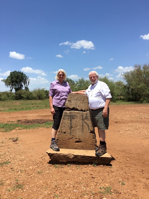 A couple posing with a monument.
