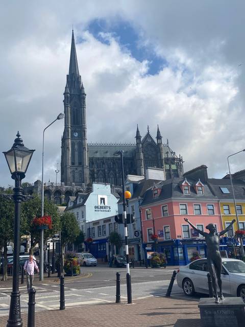 Historic church building on a busy street with colorful buildings.