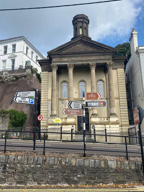 Historic building with directional signs on a street.