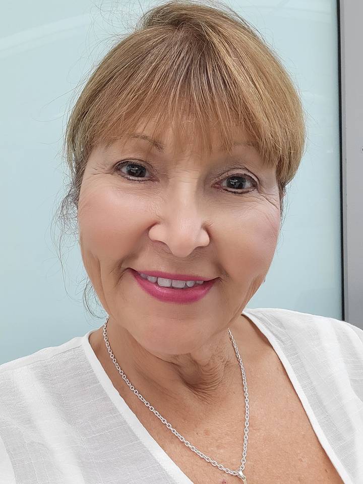 Portrait d'une femme souriante portant un collier.