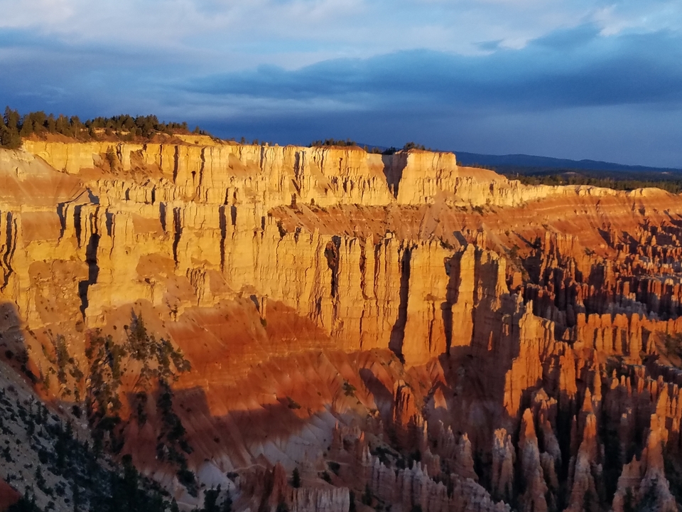 Falaises spectaculaires avec formations rocheuses stratifiées au coucher du soleil.