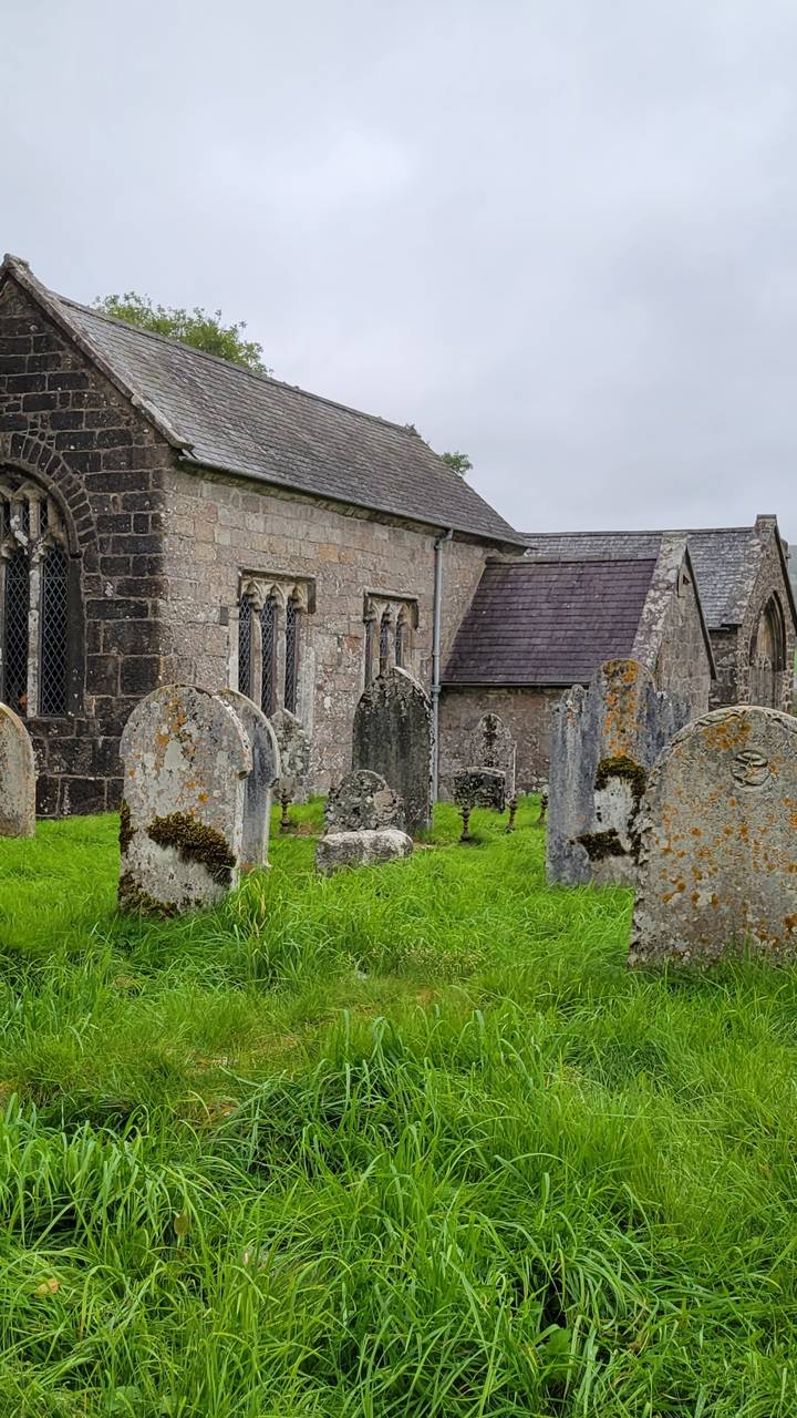 Vieille église avec pierres tombales dans un cimetière verdoyant
