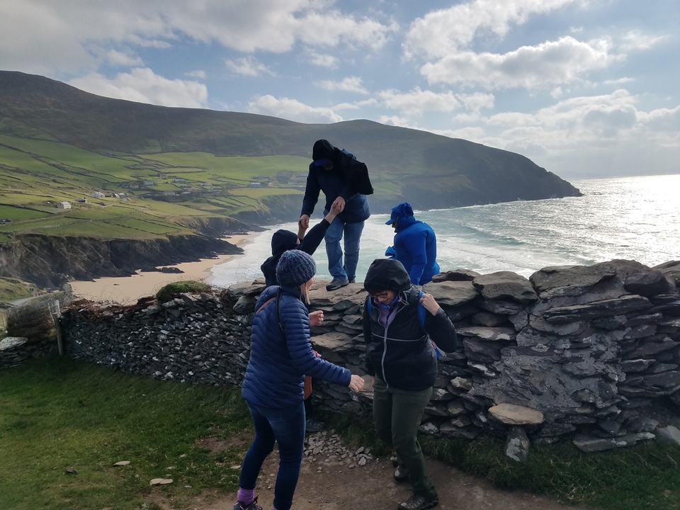 Groupe de personnes explorant des falaises au bord de la mer.