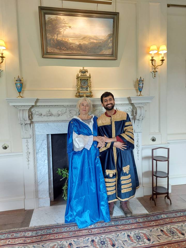 Des personnes vêtues de costumes d'époque dans une salle historique.