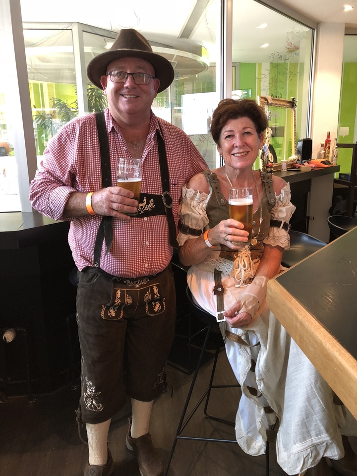 Un couple en tenues traditionnelles savourant des bières dans un bar.