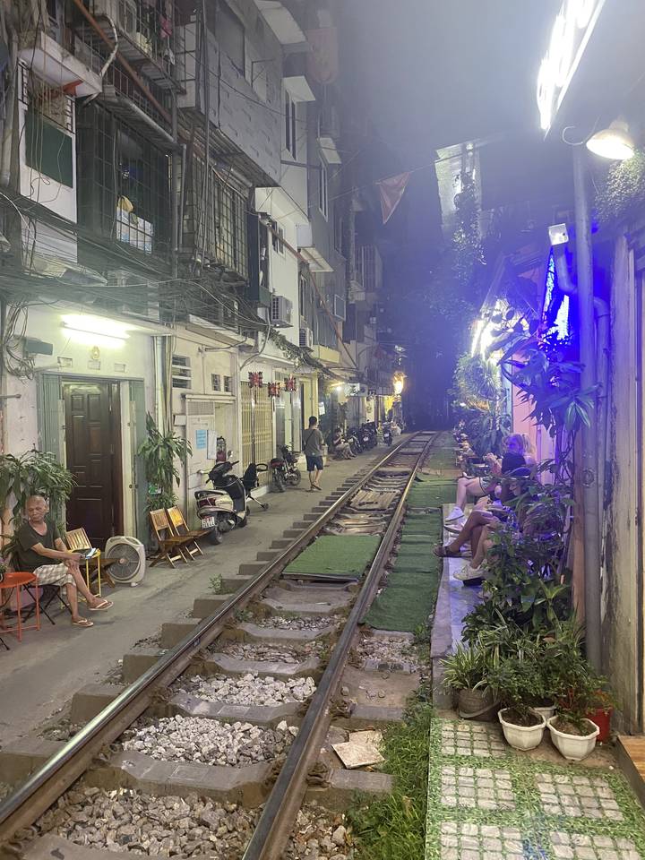 Voie ferrée étroite dans une zone urbaine animée avec des éclairages.
