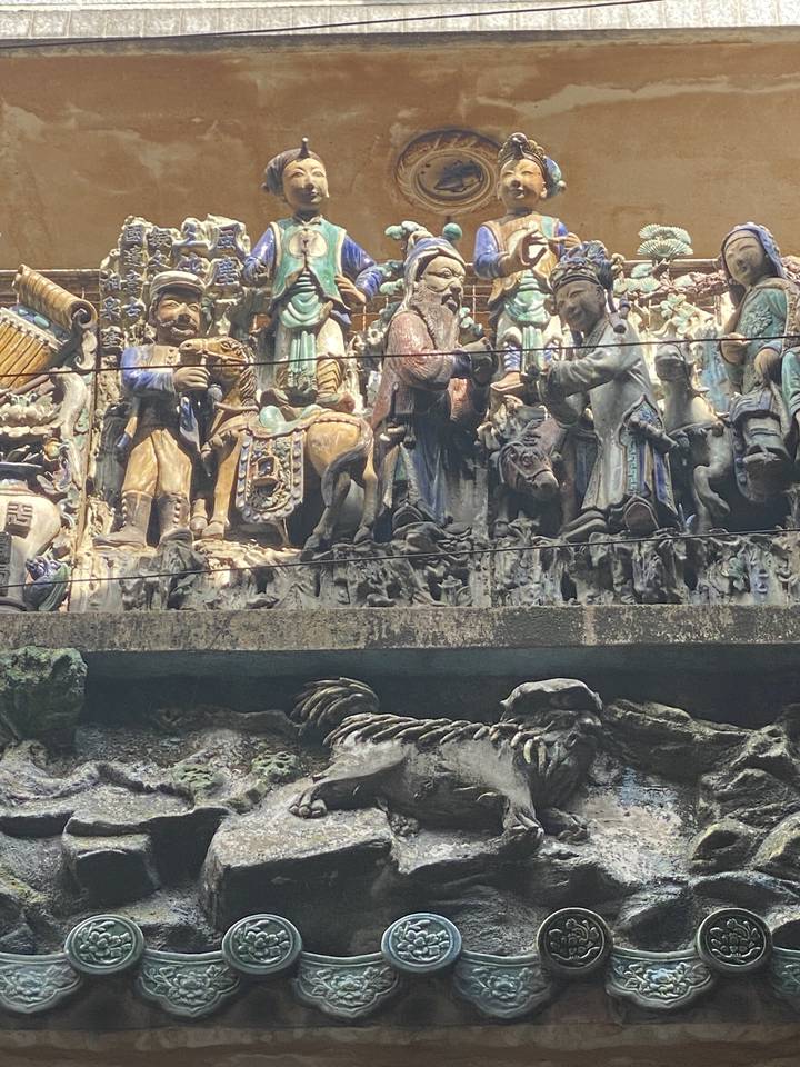 Relief en pierre sculptée avec des figures artistiques.