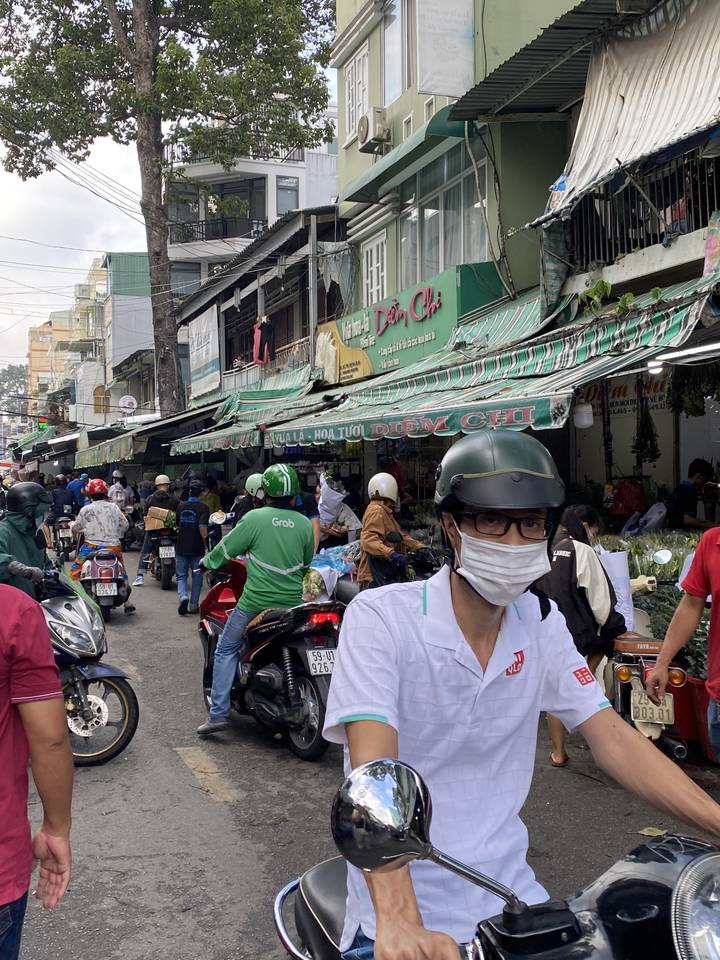 Scène de rue animée avec des motos et des magasins.