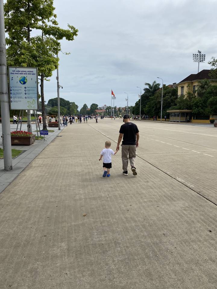 Adulte et enfant marchant le long d'une grande zone en béton.