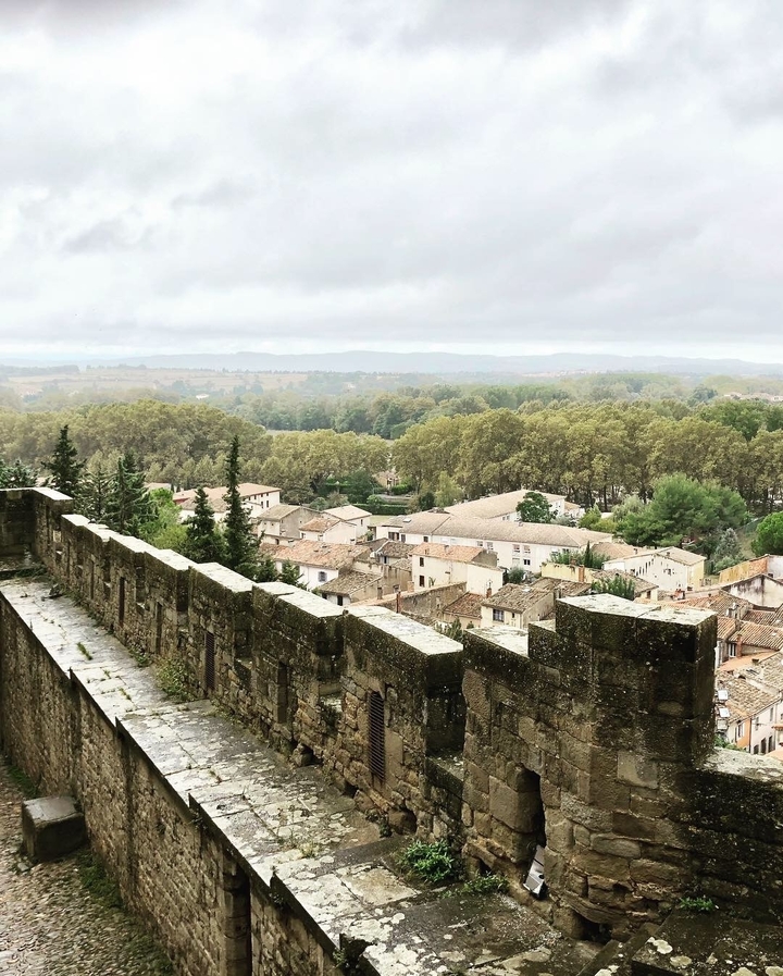 Vue panoramique d'une ville médiévale depuis un mur de pierre.