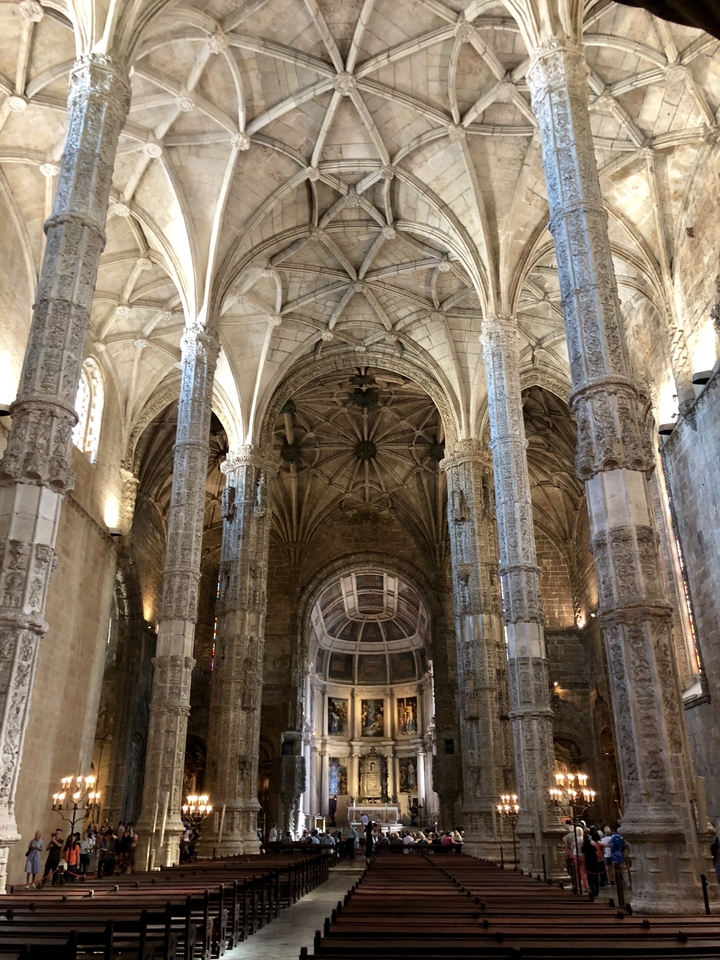 Intérieur d'une grande cathédrale avec des colonnes ornées et des voûtes.