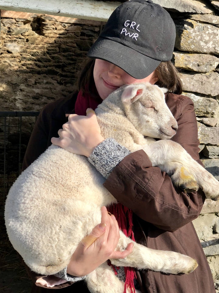 Personne tenant un agneau qui dort.