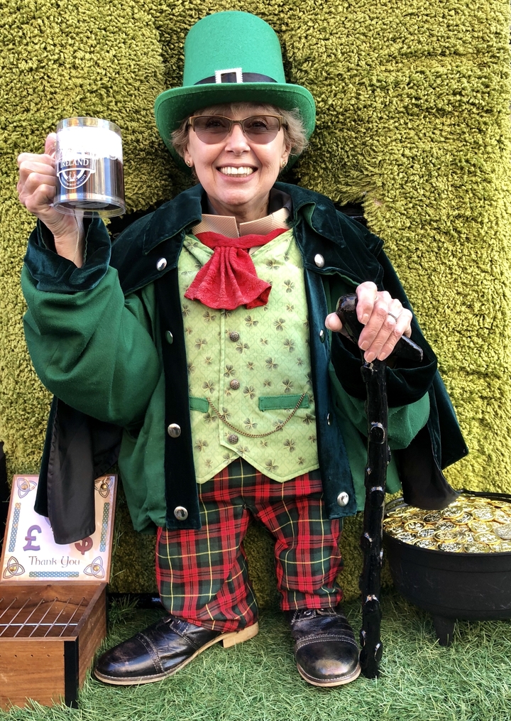 Personne vêtue de vert et de vêtements à carreaux tenant une canne de marche.