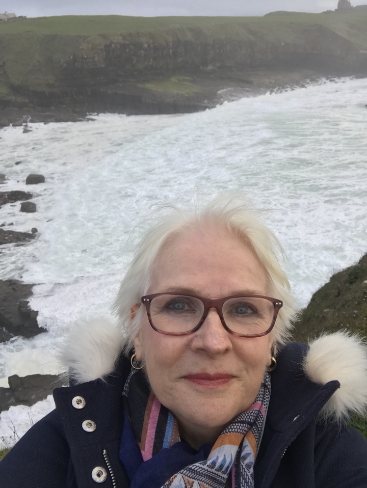 Personne prenant un selfie avec des vagues qui se brisent en arrière-plan.