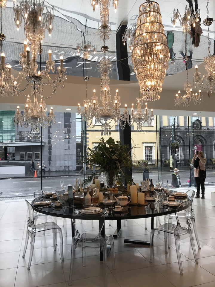Table dressé dans une salle à manger somptueuse avec des lustres.