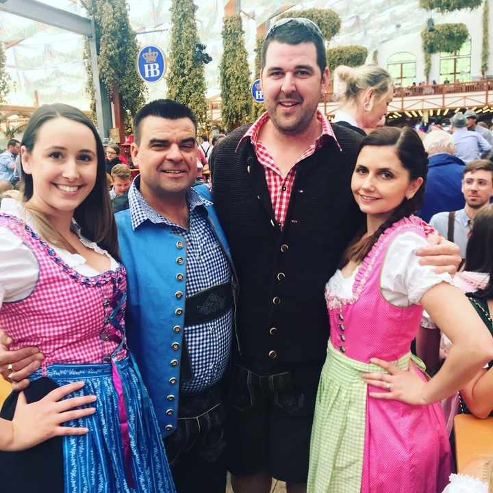 Quatre personnes en vêtements traditionnels bavarois.