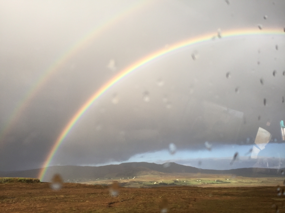A double rainbow over a landscape.