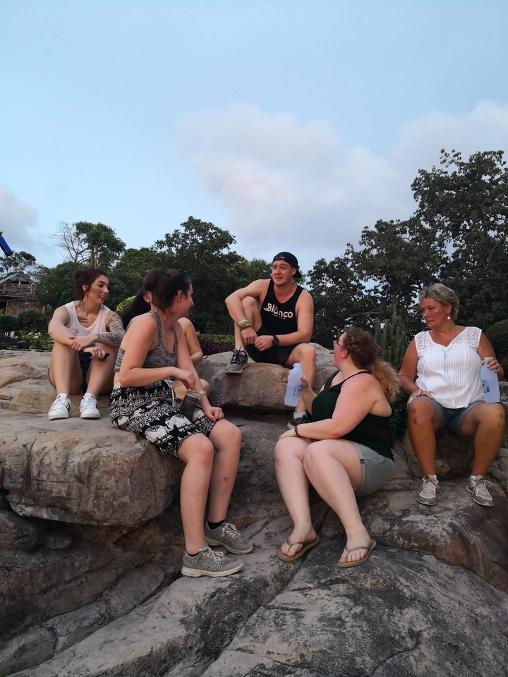 Groupe d'amis assis sur des rochers en train de discuter.