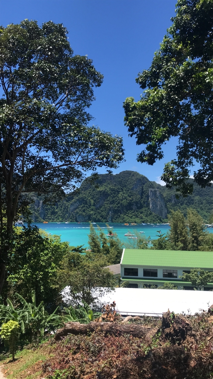 Mer bleue éclatante avec des bateaux et un arrière-plan montagneux luxuriant.