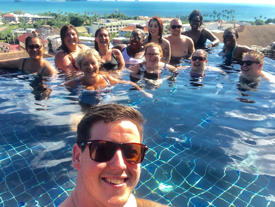 Groupe de personnes profitant d'une piscine avec vue sur la ville.