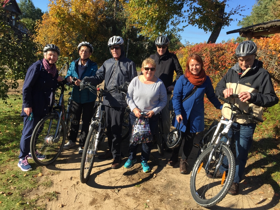 Groupe de cyclistes posant avec leurs vélos dans un parc.