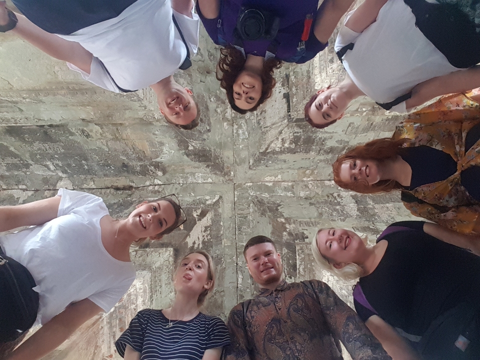 Groupe de personnes regardant vers l'appareil photo dans un cadre architectural.