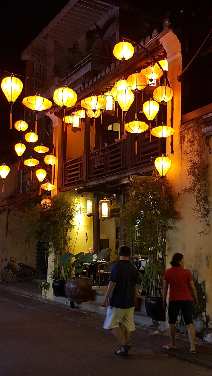 Lanternes jaunes illuminant un vieux bâtiment la nuit.