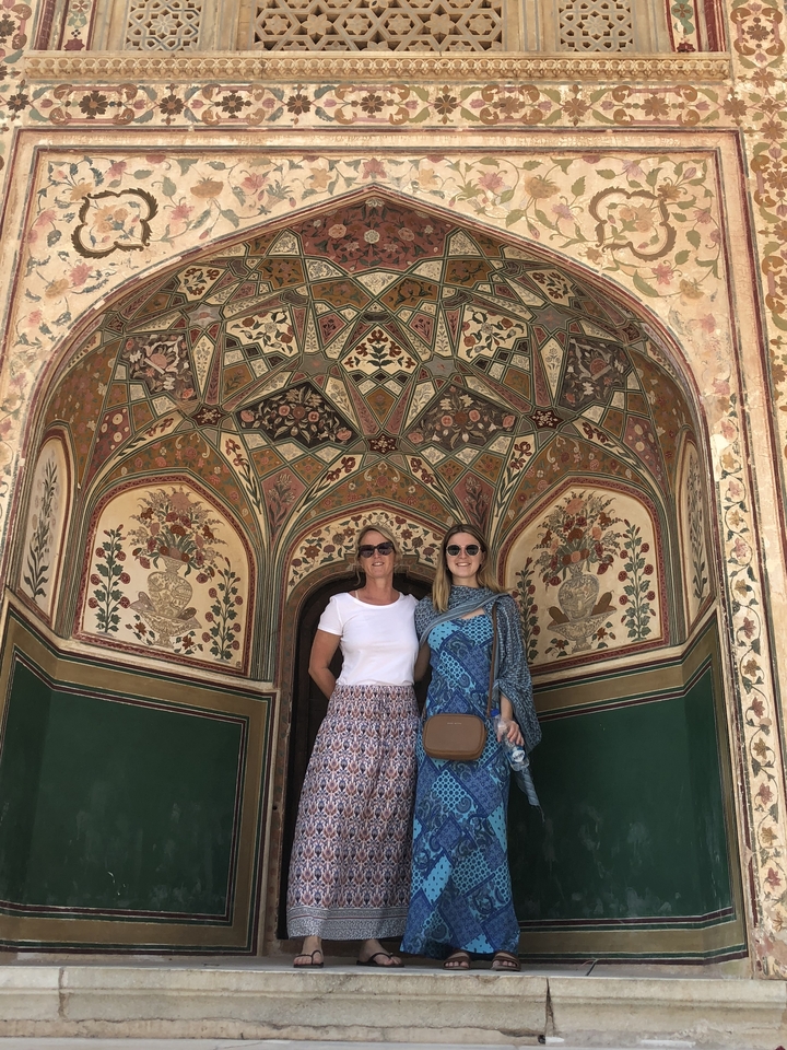 Deux femmes debout devant une arche décorative aux détails magnifiques.