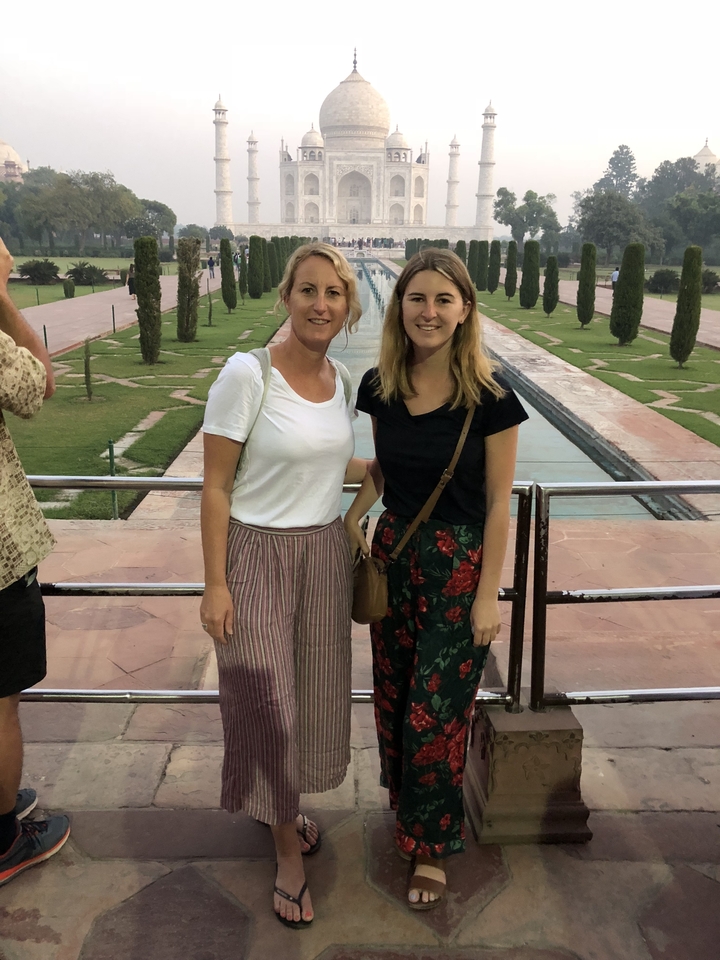 Deux femmes debout devant les jardins du Taj Mahal.