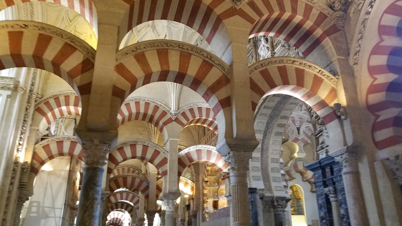 Intérieur de la Mosquée-Cathédrale de Cordoue avec des arcs rouges et blancs.