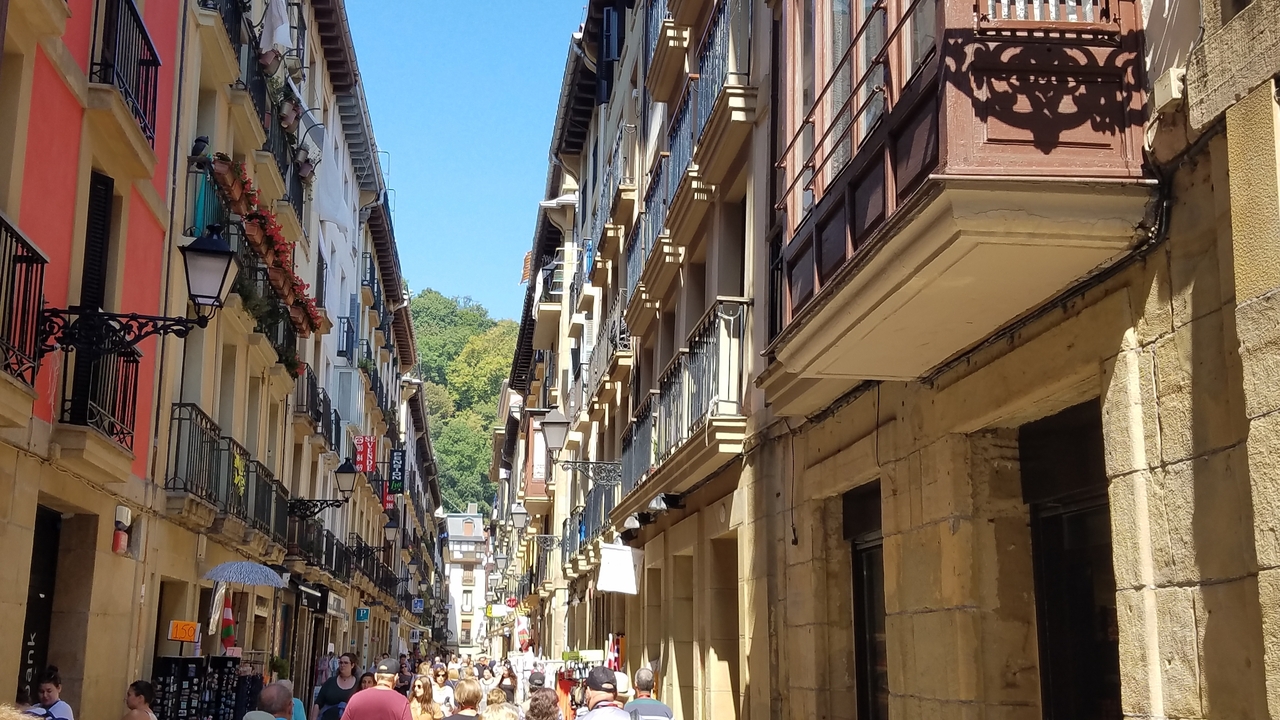 Rue bondée entre deux rangées de bâtiments traditionnels colorés.