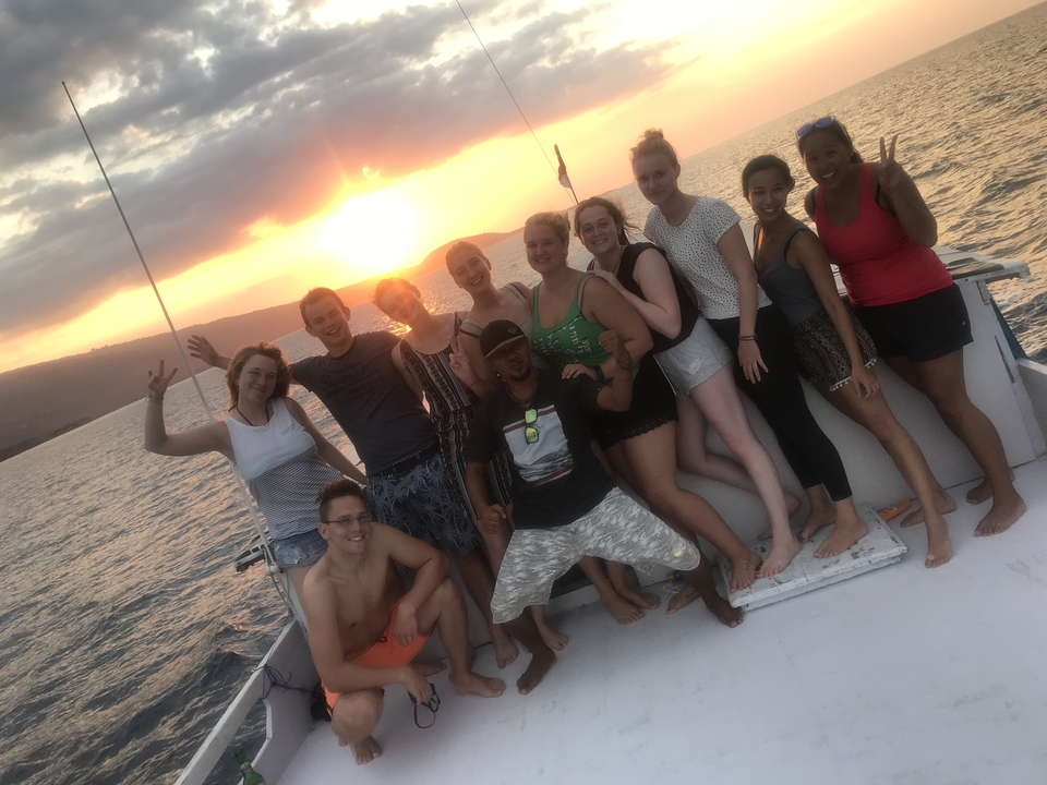 Group of people on a boat during sunset.