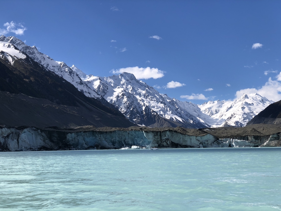 Pristine view of the glacier-fed lake with majestic snowy mountains.