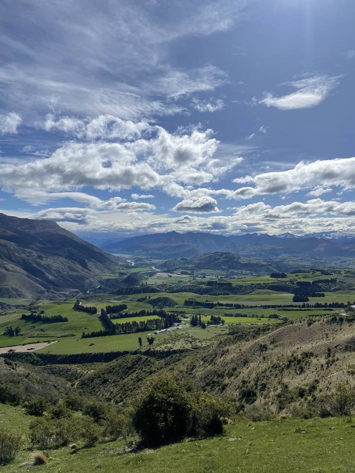 A view of lush green valleys under a blue sky.