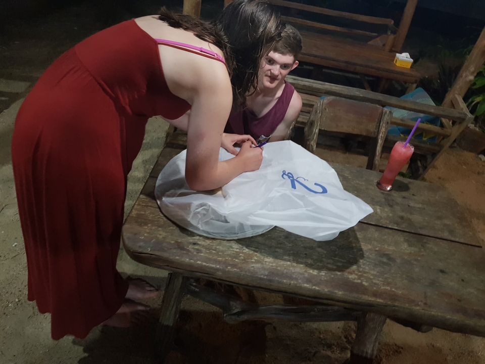 Deux personnes préparant un objet sur une table.