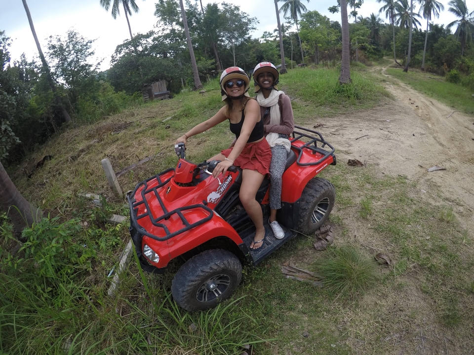 Deux personnes conduisant un VTT dans une zone forestière.