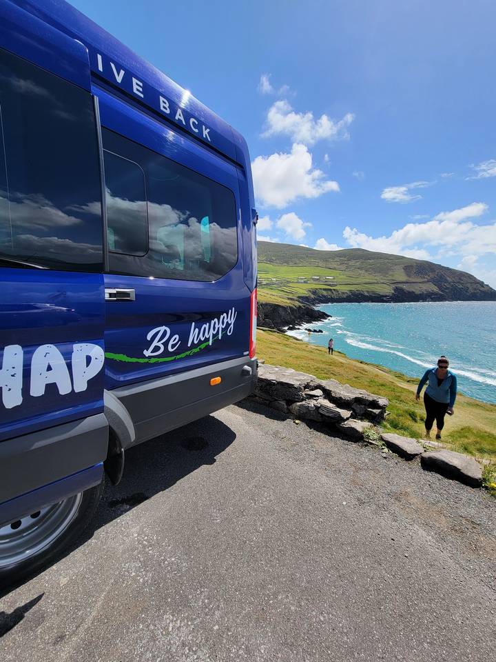 Rear view of a van with scenic coastal background.