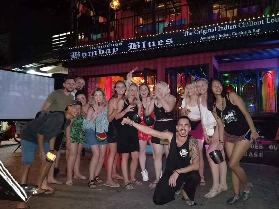 Groupe rassemblé devant un bar la nuit.