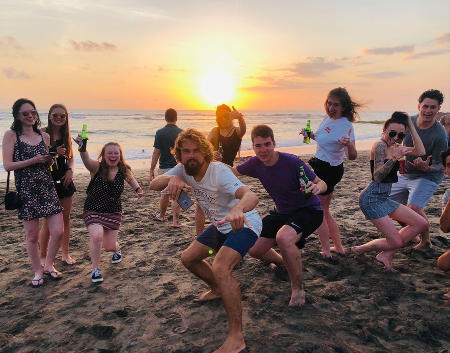 Groupe de personnes profitant d'un coucher de soleil sur la plage.