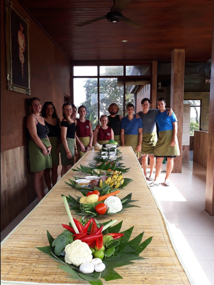 Groupe de personnes en tabliers debout près d'une table avec de la nourriture.