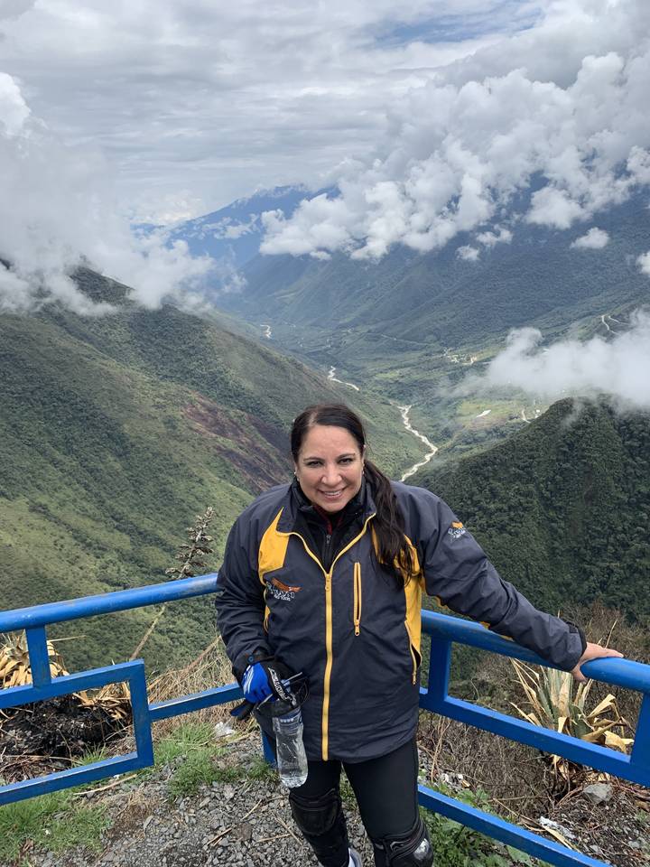 Femme qui pose devant une montagne pittoresque à un point de vue.